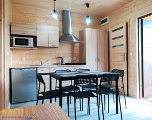 a kitchen with a table and chairs in a room at Balti Domki Letniskowe in Dębina