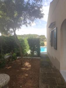 a view from the side of a building with a tree at Es Pins in Cala Blanca