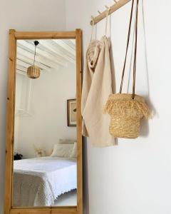 einen Spiegel in einem Zimmer mit einem Bett und einem Bett in der Unterkunft Serifos Olive in Serifos Chora