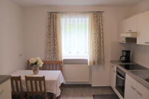 Aicha vorm WaldにあるSchöne Ferienwohnung vor den Toren Pullman Citysの花瓶に花が飾られたテーブルのあるキッチン