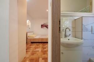 a bathroom with a sink and a bed in a room at Apartments Lucija in Trogir