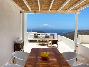 a dining room with a table and chairs on a balcony at Serifos Olive in Serifos Chora
