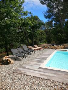 a swimming pool with chaise lounge chairs and a swimming pool at Le Soleil du Ventoux in Entrechaux