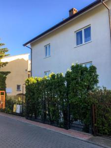 a white building with a fence in front of it at Willa Zdrój in Ciechocinek