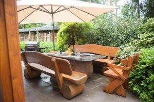 a table and chairs with an umbrella on a patio at Heidehaus Lippl am Steinhuder Meer in Rehburg-Loccum