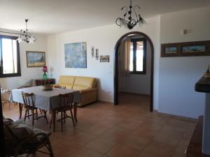 uma sala de estar com uma mesa e um sofá em Villa Le Site em Racale