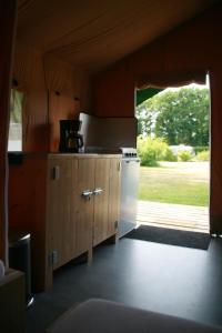 a kitchen with a stove and a door to a yard at Safaritent in Beilen