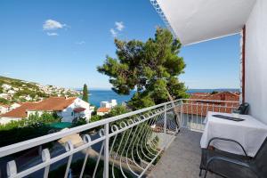 balcón con mesa y vistas al océano en Apartments Lucija, en Trogir