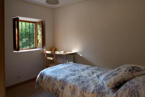 ビジャルカヨにあるCasa Rural La Casita del Ríoのベッドルーム1室(ベッド1台、デスク、窓付)