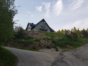 a house on top of a hill next to a road at Na Zakręcie in Ochotnica Górna