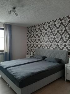 - une chambre avec un lit avec une tête de lit dans l'établissement Ferienwohnung Post, à Ommersheim