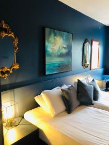 um quarto com uma cama com uma parede azul em The Waterside Apartment 112 Harbour Mills em Westport