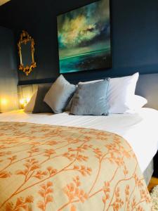 um quarto com uma cama grande e uma pintura na parede em The Waterside Apartment 112 Harbour Mills em Westport