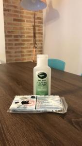 a bottle of horse breath therapy sitting on a table with a newspaper at Laura Sea View Apartment in Valencia