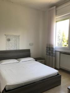a bedroom with a large white bed with a window at Eagle Rooms in Riva del Garda