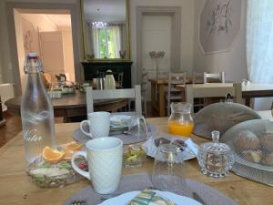 einen Tisch mit einer Flasche Orangensaft und Teller mit Lebensmitteln in der Unterkunft Moulin d'Amour in Chambon