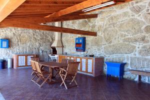 ein Esszimmer mit einem Tisch und Stühlen in einer Steinmauer in der Unterkunft Casa das Leiras in Vieira do Minho