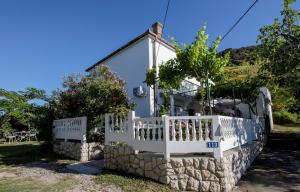 a white fence in front of a house at Holiday House Predrag in Rab