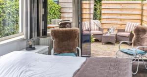a porch with a bed and chairs on a patio at B&B Carpe Diem in Hulst