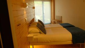 a bedroom with a bed and a window in it at Casa Sulfato in Campo do Gerês