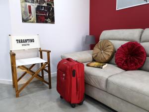 uma mala vermelha sentada no chão ao lado de um sofá em Vila Maior na Sertã
