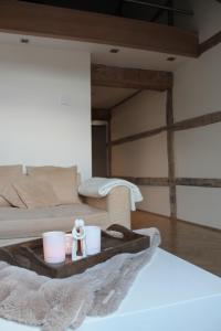 a bed with a tray with two cups and a towel at Apartment De Maasnacht in Maaseik