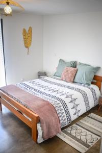 a bed with a comforter on it in a room at détente et confort - gite baie bocage in Sartilly