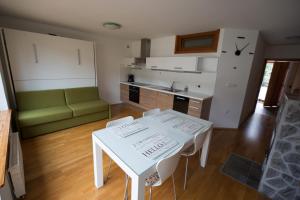 a living room with a white table and a kitchen at APARTMENT ALPIN BOVEC in Bovec