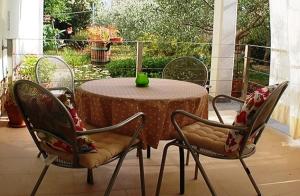 una mesa con sillas y un jarrón verde. en CECILLIA Mare Apartments, en Rovinj
