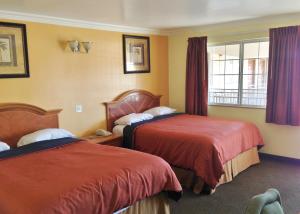 a hotel room with two beds and a window at Downtown Motel 7 in San Bernardino