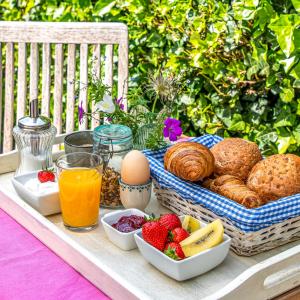 a picnic table with breakfast foods and a basket of bread at B&B Carpe Diem in Hulst