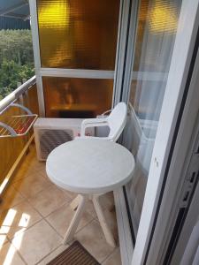 einen kleinen weißen Tisch und einen Stuhl auf dem Balkon in der Unterkunft Neptun Apartman in Balatonföldvár