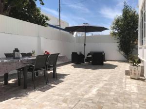 a patio with a table and an umbrella at Villa Maria Alvor in Alvor