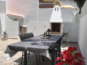 a black table with chairs and a white lamp at Villa Maria Alvor in Alvor