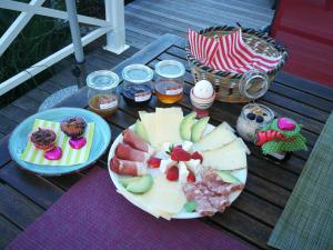 a table with two plates of food on a deck at B&B Whitianga in Vinelz