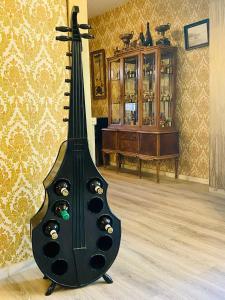una chitarra nera seduta sul pavimento in una stanza di Villa Palma a Marbella