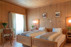 ein Schlafzimmer mit einem großen Bett in einem Zimmer mit Holzwänden in der Unterkunft Altavilla, Rooms & Breakfast in Poschiavo