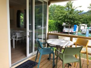 a patio with a table and chairs on a porch at Mobilhome Camping Azzurro in Ledro