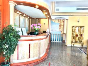 a lobby of a hotel with a counter with flowers at Hotel Margherita in Lido di Jesolo