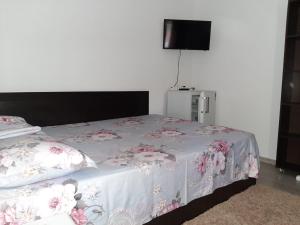 a bedroom with a bed with a white and pink blanket at Casa Elena in Constanţa