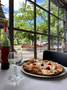 カルカソンヌにあるラ ラピエールのワインを飲みながらテーブルに座るピザ