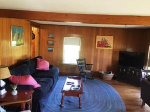 a living room with a couch and a tv at Sea Rose Cottage in Owls Head