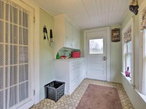 una pequeña cocina con puerta blanca y ventana en Sea Rose Cottage en Owls Head