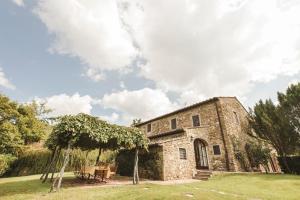 an old stone building with a tree in front of it at La Veronica Exclusive Chianti Resort in Greve in Chianti
