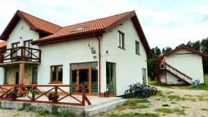 Casa blanca con techo rojo en Eco domki, en Ruciane-Nida