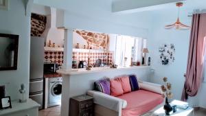 a living room with a couch with a pink blanket at Appartement de charme au coeur de Saint-Tropez in Saint-Tropez