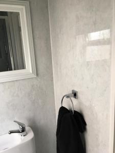 a bathroom with a sink and a mirror and a towel at Donegal Court Yard in Chapel Saint Leonards