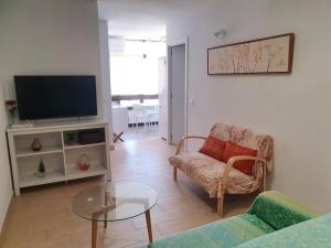 フエンヒロラにあるApartamento junto al puerto de Fuengirolaのリビングルーム(テレビ、ソファ、テーブル付)