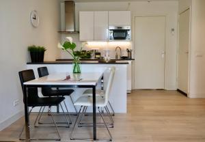 Una cocina y un comedor con mesa y sillas. en Frankendael Apartments, en Ámsterdam
