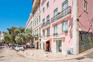 eine Straße in einer Stadt mit rosa Gebäuden in der Unterkunft Residencial Geres in Lissabon